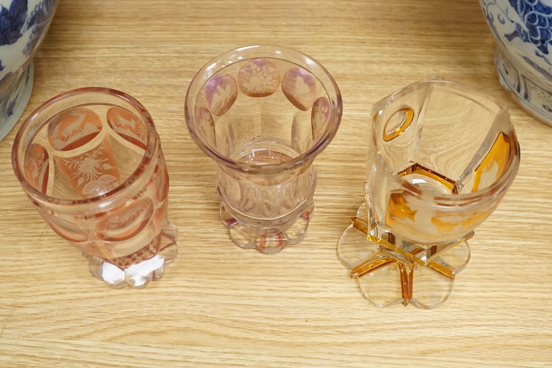Three Bohemian colour flashed glass goblets, late 19th century, two with hunting subjects, the third decorated with insects, birds and flowers